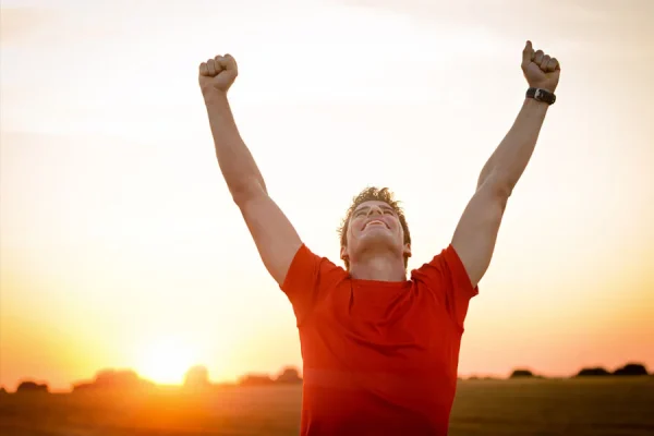 Young man raising his hands concept image for a successful recovery process